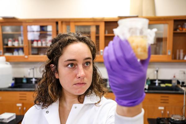 Female student holding a beaker containing fluid