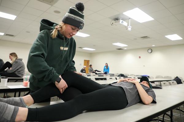 Student performing physical therapy on someone